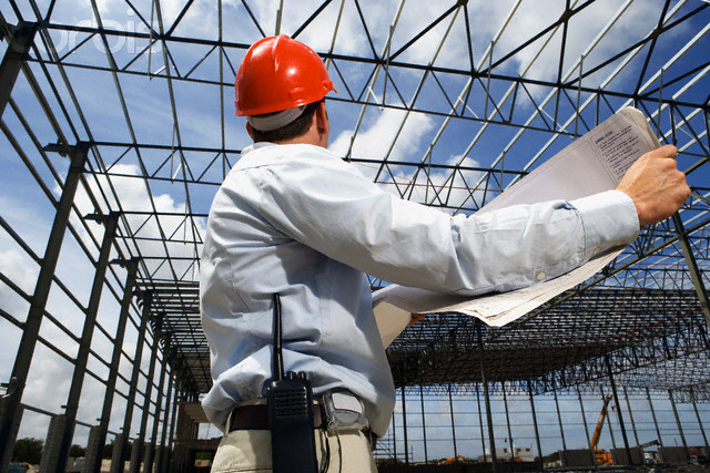 Construction Worker Holding Plans on Building Site